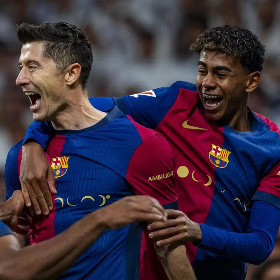 Deux joueurs de football masculins en maillots rayés bleus et rouges célébrant.