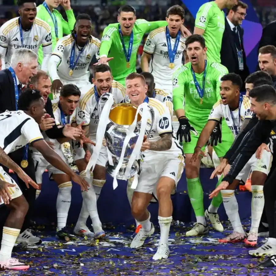 Un groupe de joueurs de football célébrant avec un trophée.