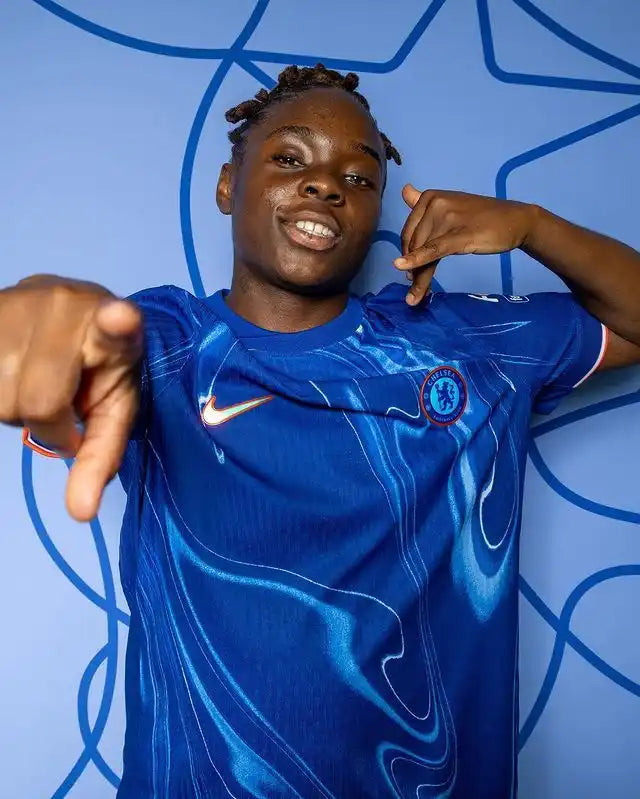 Une personne portant un maillot de football Chelsea bleu.